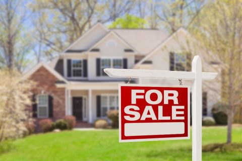 House with a For Sale sign in the front garden