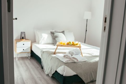 Guest bedroom with fresh towels and a breakfast tray on the bed