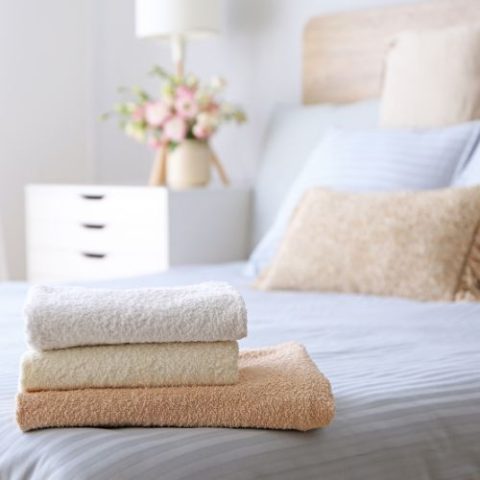 Freshly made bed with folded towels
